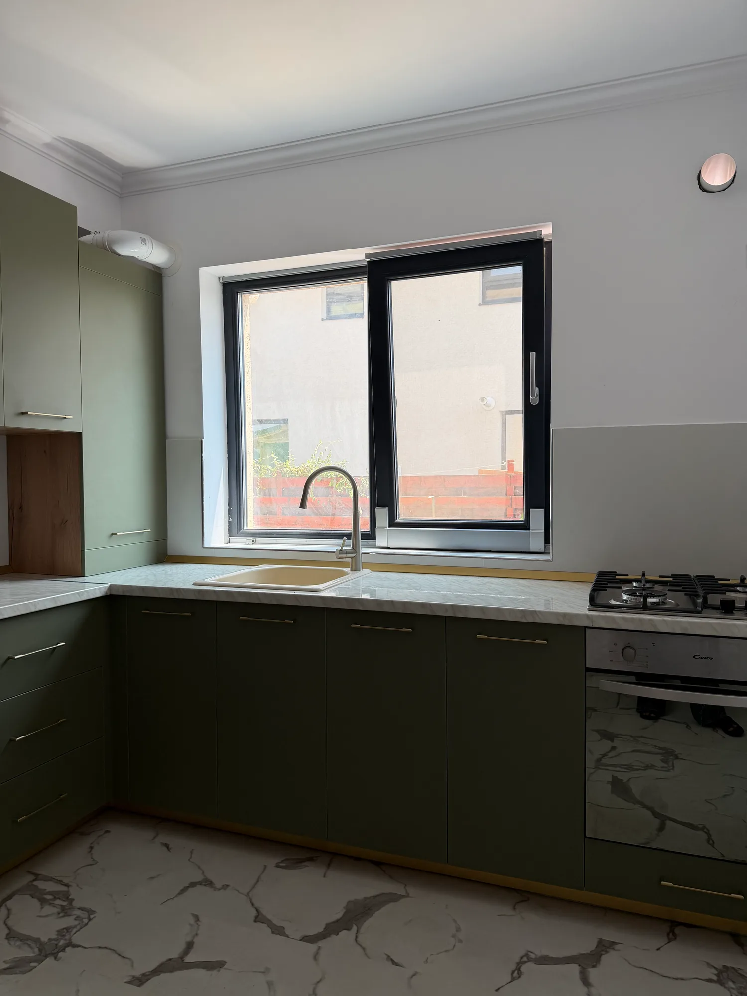 Zona de lucru de lângă fereastră, cu blat aspect marmură și baterie înaltă